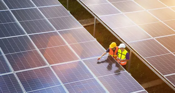 Workers inspecting a solar panel