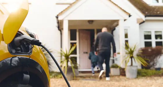 electric car charging on driveway outside house