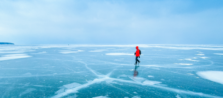 Man walking across frozen lake