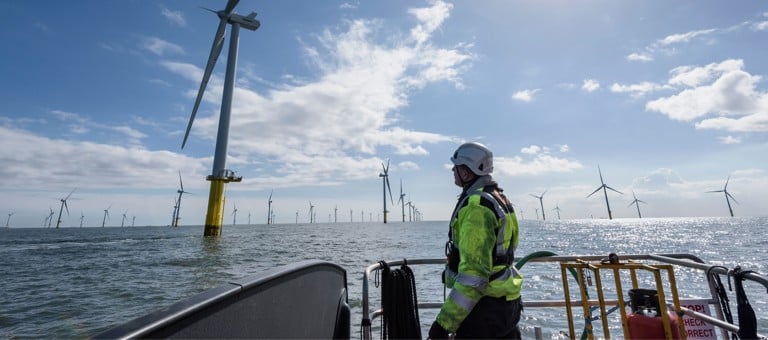 Worker on a boat inspecting an offshore wind farm
