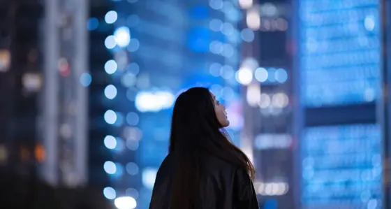 Woman looking up at buildings