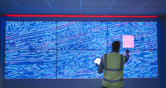 A man pressing a large interactive screen
