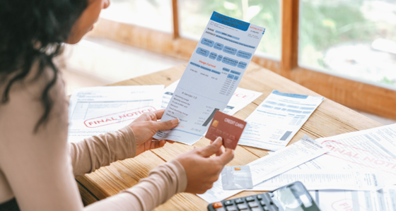 Person looking at a bill and holding a credit card