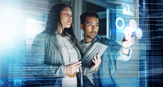 Two people looking at graphs on a transparent screen