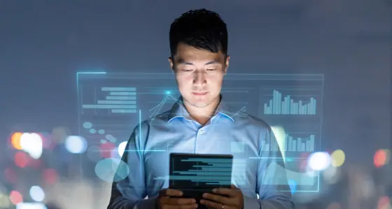 A man looking at a tablet with graphics overlay