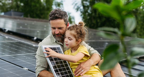 Father and daughter on the rooftop full of solar panels