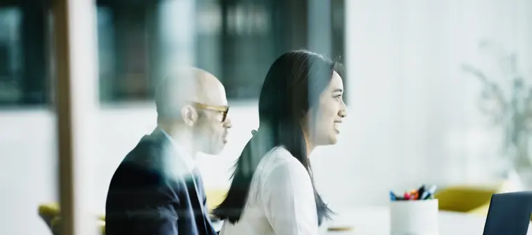 A man and a woman in profile in a meeting