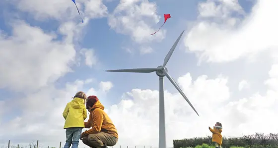 Father with his children in front of a wind turbine