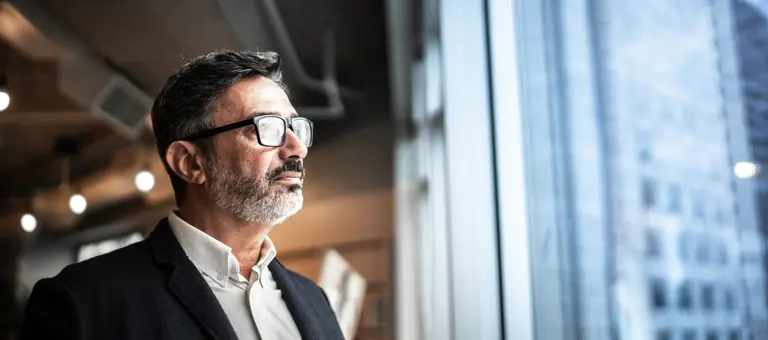 business man looking out of window at city