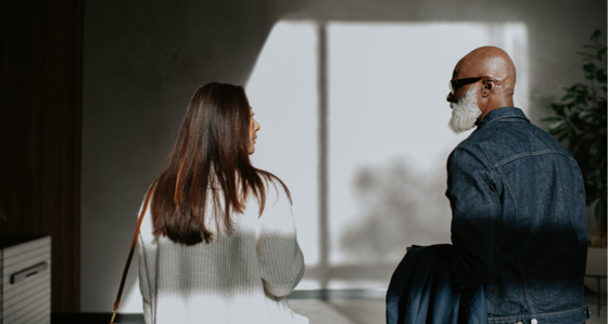 man and a woman standing next to each other, and walking away from the camera