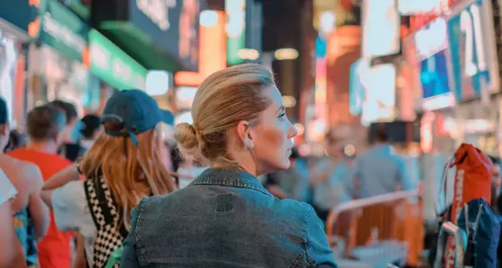 Woman stood in the city surrounded by advertising screens