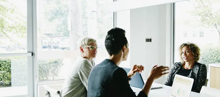 Three women having a conversation in an office