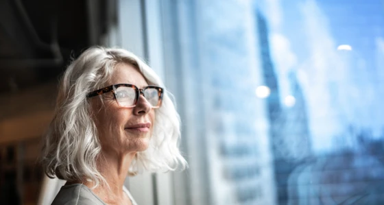 Mature business woman looking out window