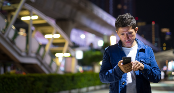 Man looking at his smartphone on the street