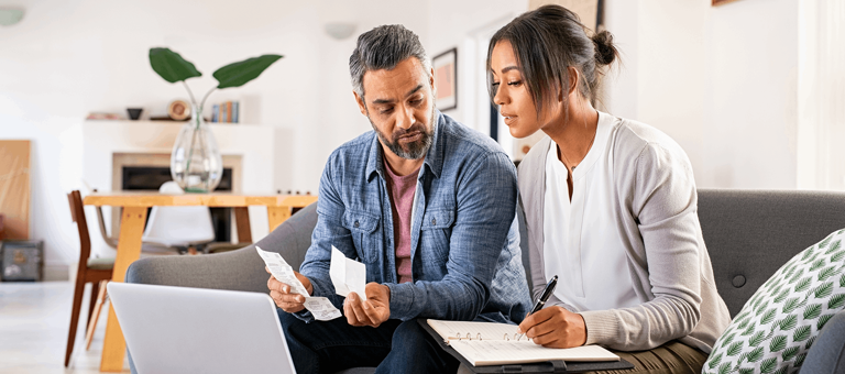 A woman and a man looking at receipts and bills