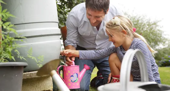 A father and his daughter filling up a watering can