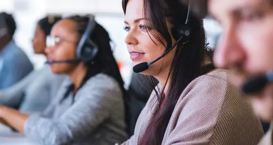 Call centre staff wearing headsets in front of their computers