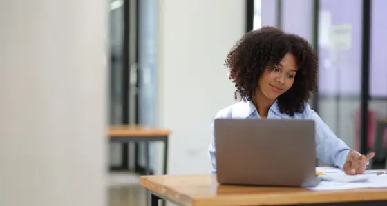 Woman smiling and looking at her laptop